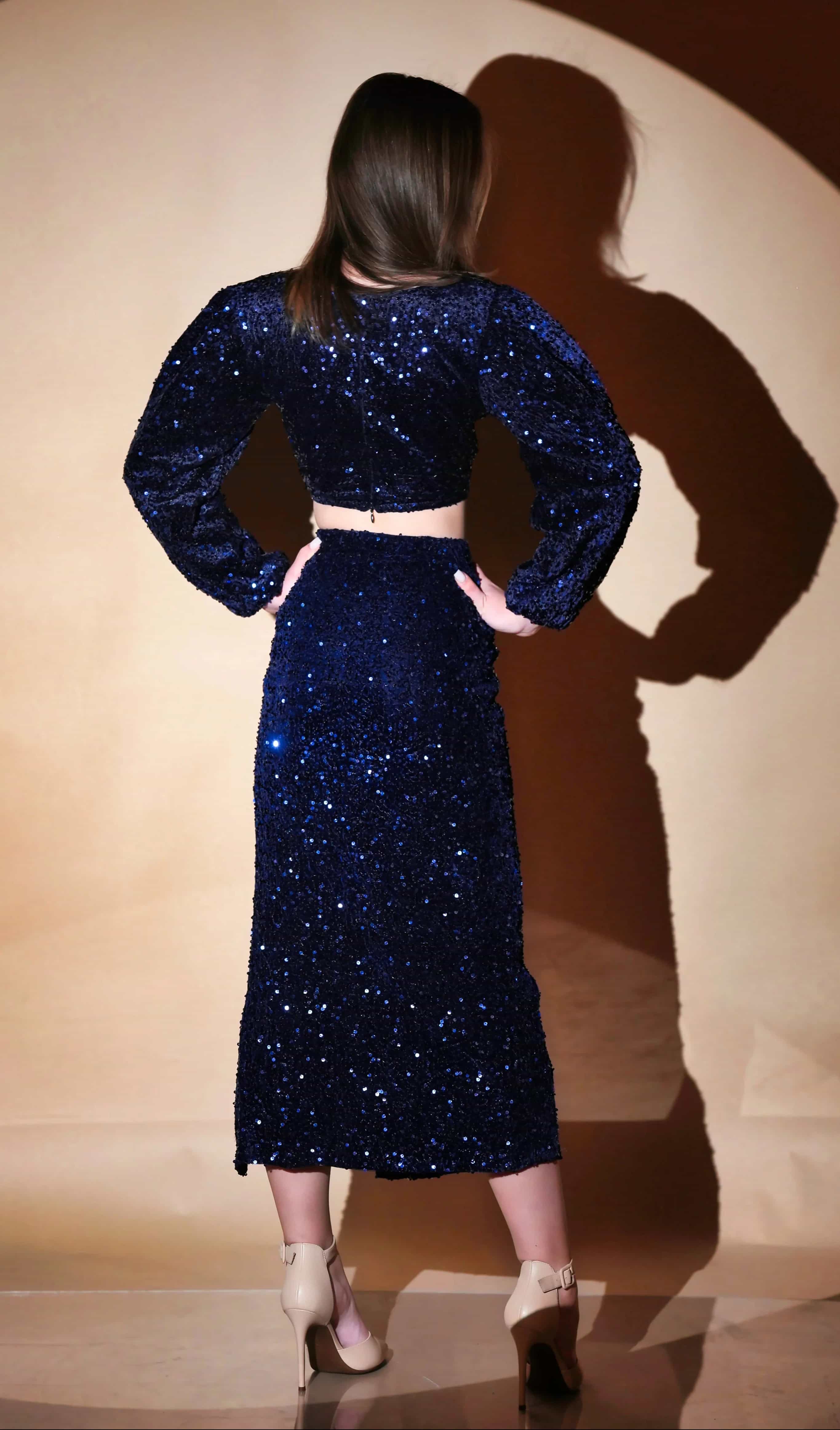 Blue velvet sequin top with V-neck, long sleeves, and slit skirt.